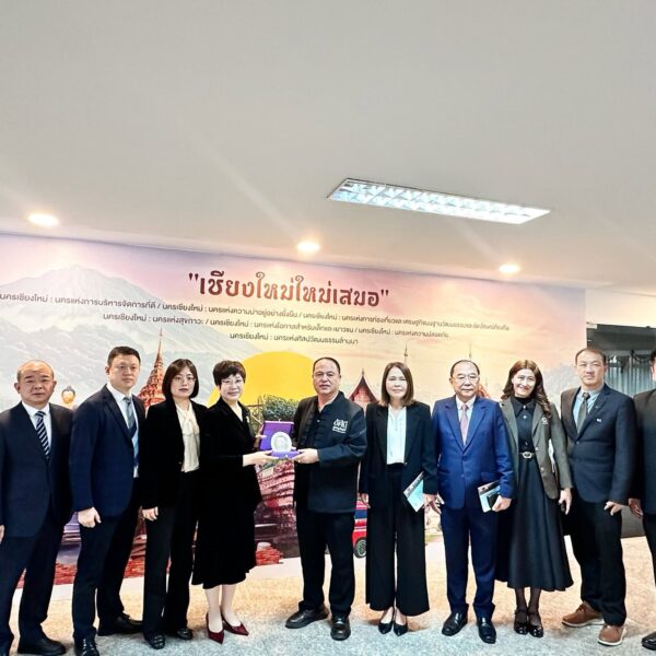 คณะผู้เข้าร่วมประชุมถ่ายภาพหมู่ร่วมกันในห้องรับรอง ศาลากลางจังหวัดเชียงใหม่ ฉากหลังเป็นภาพวาดสถานที่สำคัญ