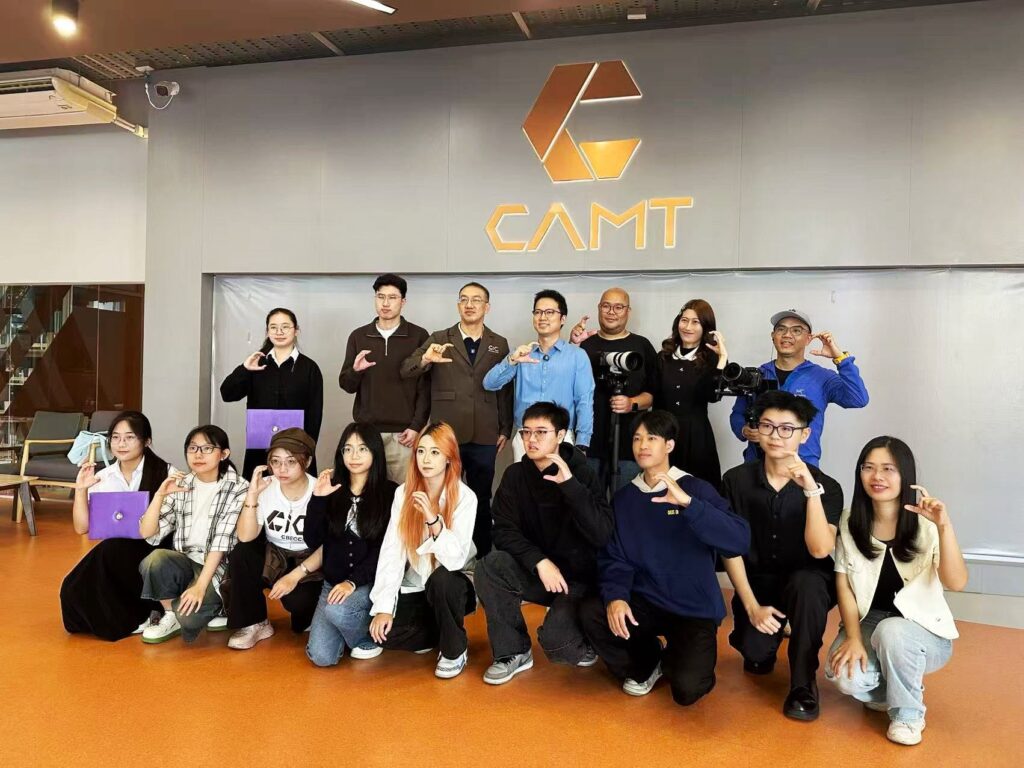 คณะอาจารย์ วิทยากร และนักศึกษาถ่ายภาพหมู่ร่วมกันหน้าโลโก้ CAMT วิทยาลัยสื่อ ศิลปะ และเทคโนโลยี มหาวิทยาลัยเชียงใหม่