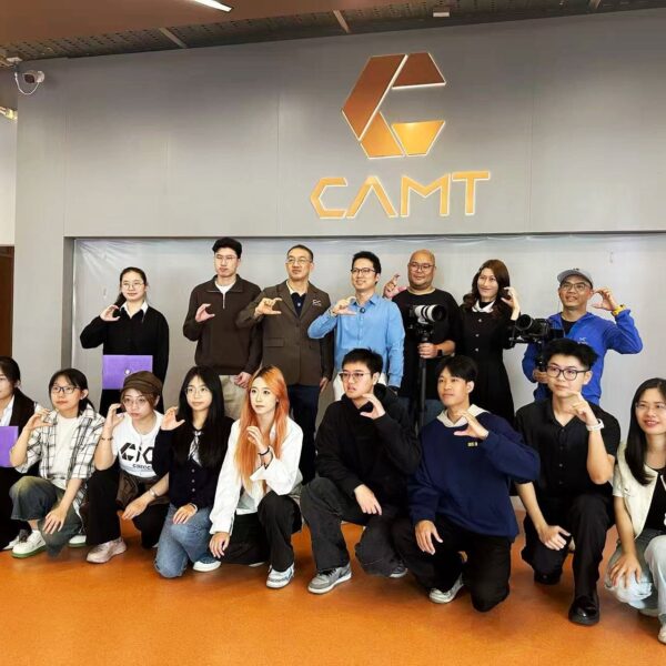 คณะอาจารย์ วิทยากร และนักศึกษาถ่ายภาพหมู่ร่วมกันหน้าโลโก้ CAMT วิทยาลัยสื่อ ศิลปะ และเทคโนโลยี มหาวิทยาลัยเชียงใหม่