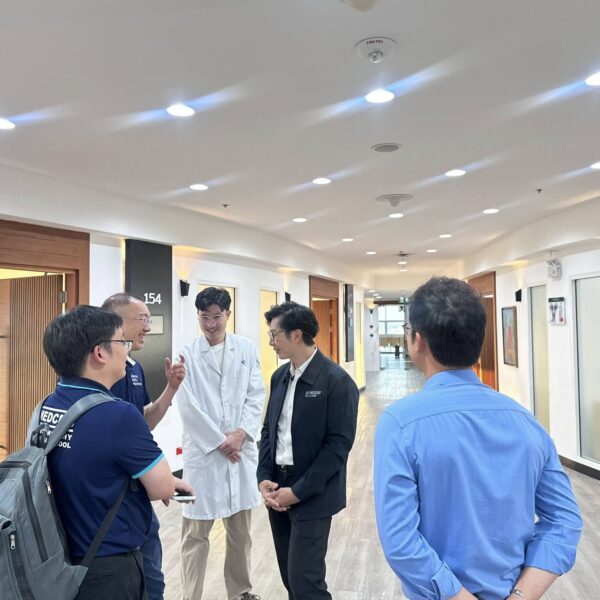 แพทย์และทีมงานยืนพูดคุยแลกเปลี่ยนความคิดเห็นบริเวณโถงทางเดินหน้าห้องตรวจ คณะแพทยศาสตร์ มหาวิทยาลัยเชียงใหม่
