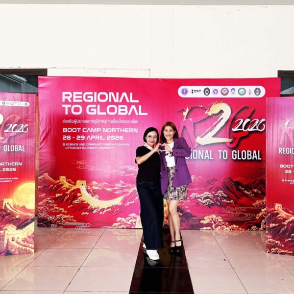 ผู้เข้าร่วมอบรมทำท่ามือเป็นรูปหัวใจด้านหน้าป้าย Backdrop Regional to Global (R2G) Boot Camp Northern วันที่ 28-29 เมษายน 2569 ณ อาคารอุทยานวิทยาศาสตร์ มหาวิทยาลัยราชภัฏอุตรดิตถ์