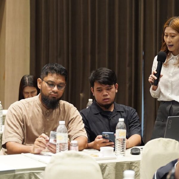 วิทยากรหญิงแชร์ประสบการณ์และตอบข้อซักถามผ่านไมโครโฟน โดยมีผู้เข้าร่วมอบรมชายสองท่านนั่งฟังและตรวจสอบข้อมูลผ่านสมาร์ทโฟนในห้องสัมมนา โรงแรมคริสตัล หาดใหญ่
