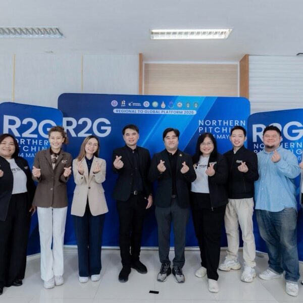 คณะทำงานและวิทยากรผู้เชี่ยวชาญ 8 ท่าน ยืนเรียงแถวหน้ากระดานทำท่าส่งมินิฮาร์ท ถ่ายภาพร่วมกันหน้าป้าย Backdrop สีน้ำเงินระบุข้อความ R2G Northern Pitching 2026 ณ มหาวิทยาลัยราชภัฏพิบูลสงคราม