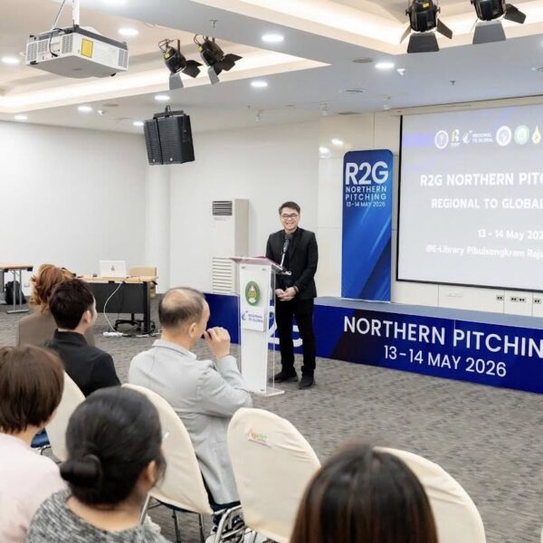 บรรยากาศมุมกว้างภายในห้อง E-Library มหาวิทยาลัยราชภัฏพิบูลสงคราม ในงาน R2G Northern Pitching 2026 วันที่ 13-14 May 2026 มีวิทยากรชายยืนกล่าวบนโพเดียม หน้าจอโปรเจกเตอร์ขนาดใหญ่แสดงข้อความ Regional to Global Platform