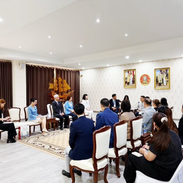 ภาพถ่ายมุมกว้างภายในห้องประชุมรับรอง ตกแต่งด้วยโมเดลเรือสุพรรณหงส์จำลอง คณะผู้เข้าร่วมประชุมชาวไทยและชาวจีนนั่งฟังการบรรยายและจดบันทึกข้อตกลงความร่วมมือ